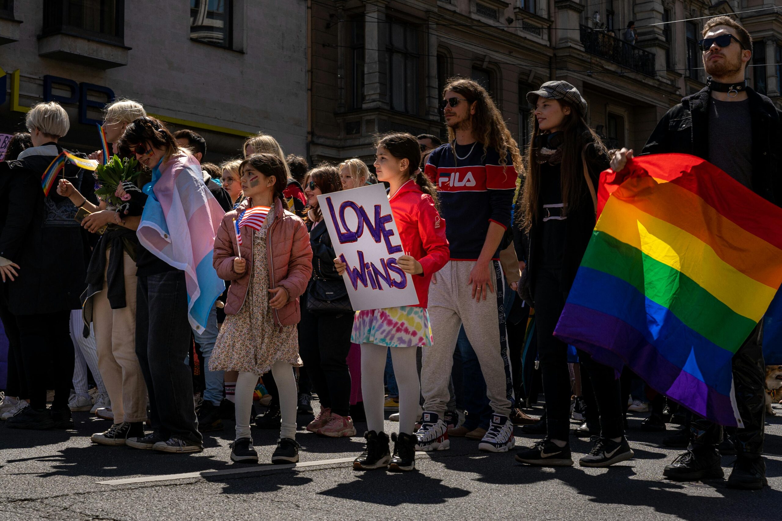 Celebrate diversity with a vibrant Pride parade featuring a Love Wins sign and rainbow flag in Riga, Latvia.