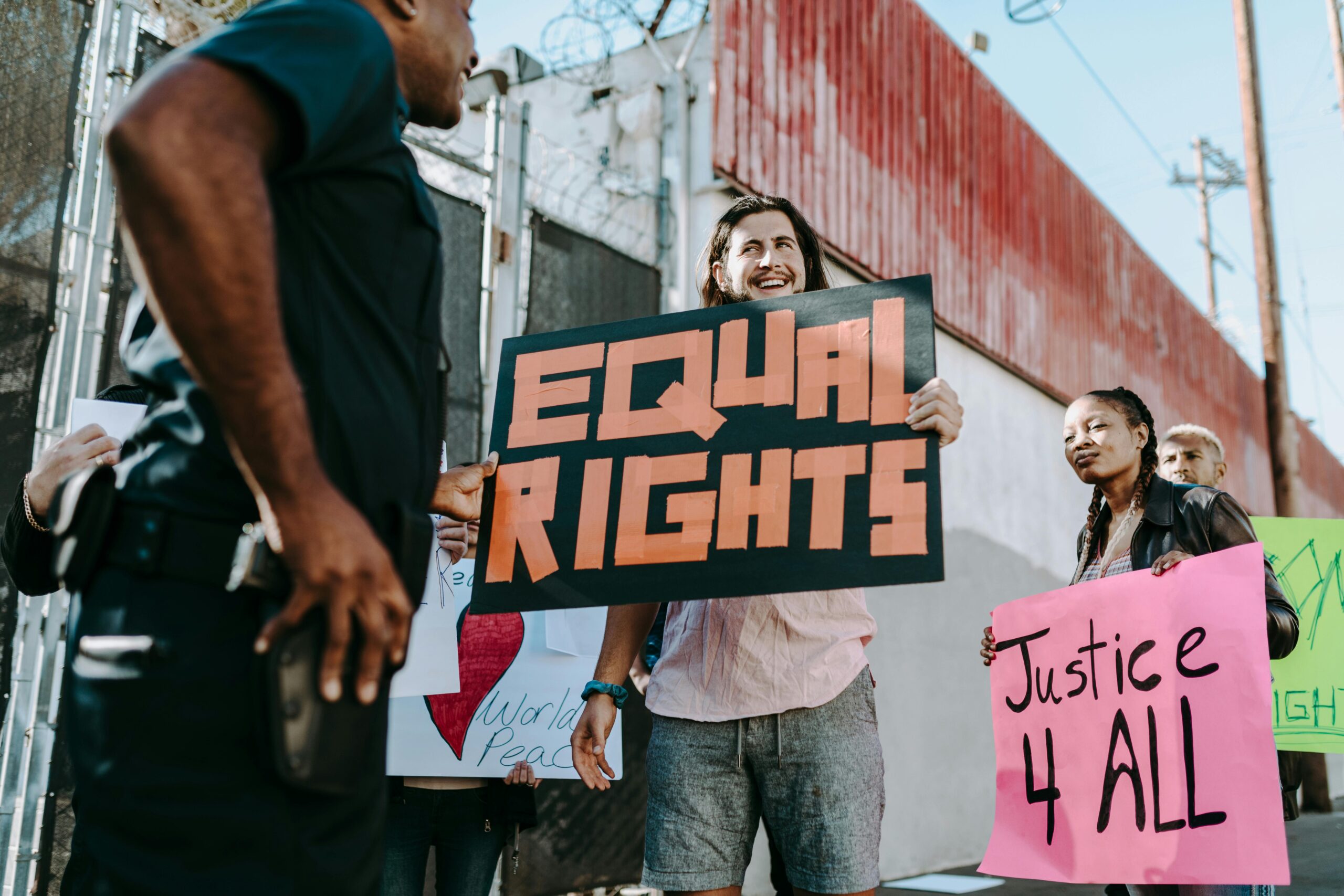 Diverse group of activists holding signs for equal rights and justice at a protest.